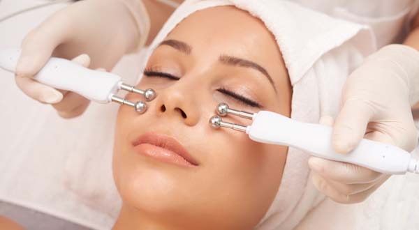 close up of a woman with towel around face getting a hycradermie facial