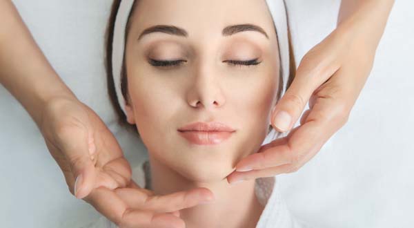 woman getting a facial massage during skin care treatment