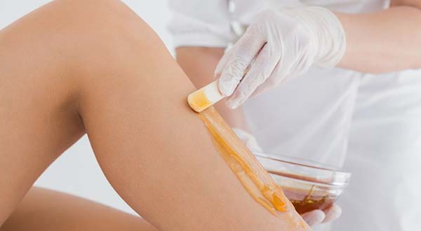 wax being applied to a woman leg during a waxing session