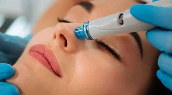 woman getting a hydrafacial treatment on the areas around her nose